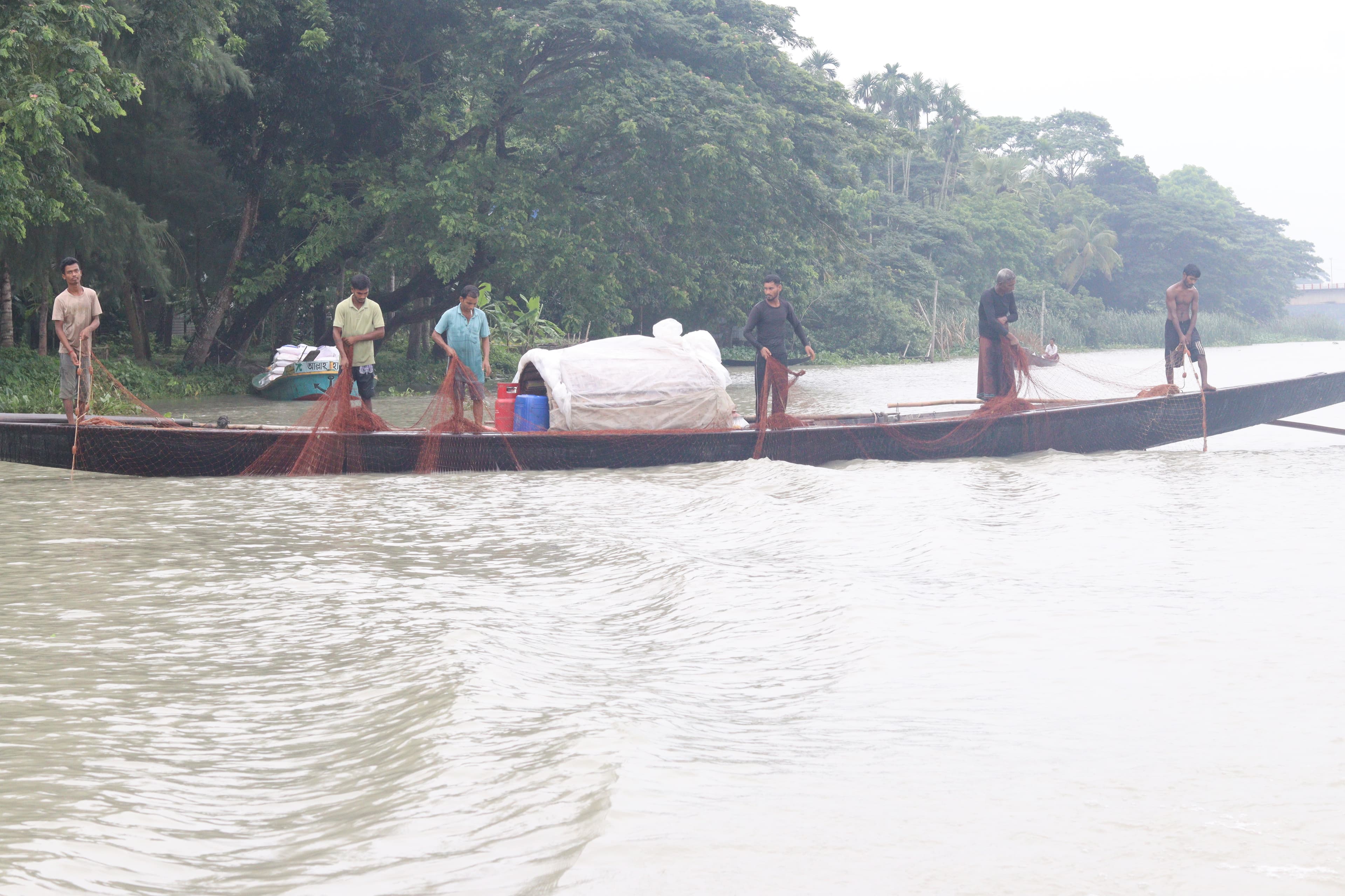 Fishers working together on a river in Bangladesh